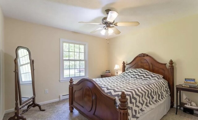 bedroom featuring a baseboard heating unit, light colored carpet, and ceiling fan