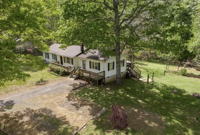 ranch-style home featuring driveway, crawl space, stairs, a wooden deck, and a front lawn