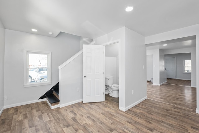 interior space with baseboards, stairway, and wood finished floors