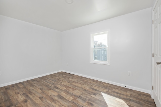 empty room with baseboards and wood finished floors