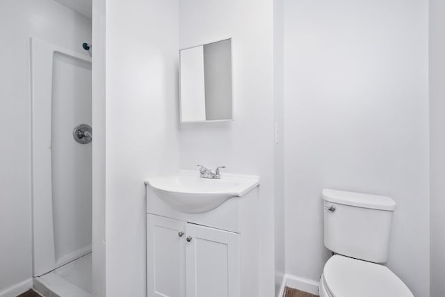 bathroom with vanity, toilet, and baseboards