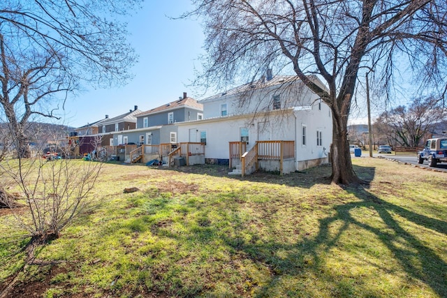 back of property featuring a residential view, a yard, and a chimney