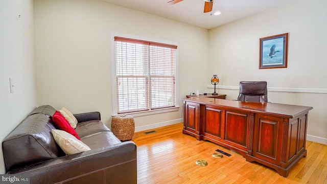 home office with light wood-type flooring and ceiling fan