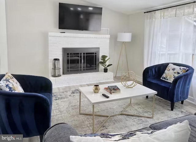 living room with a fireplace, wood finished floors, and baseboards