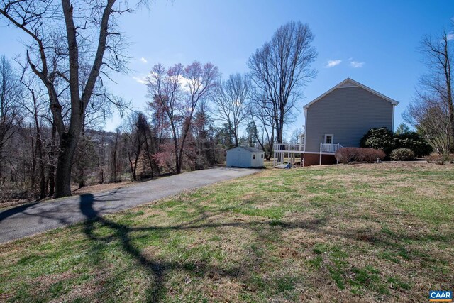 back of property featuring a wooden deck and a shed