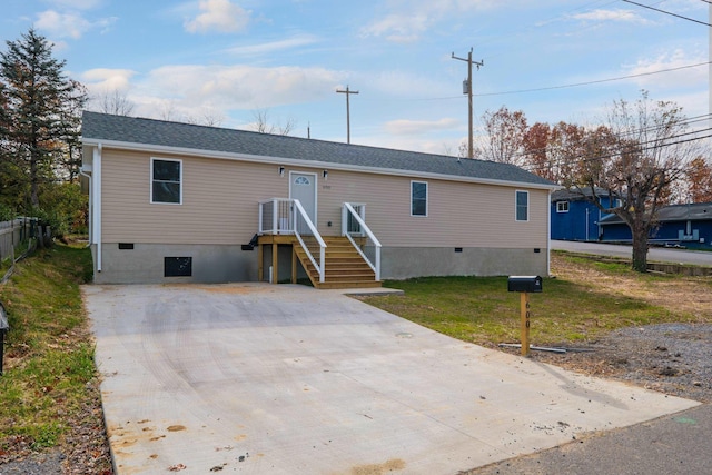 view of front facade featuring a shingled roof, a front yard, concrete driveway, and crawl space