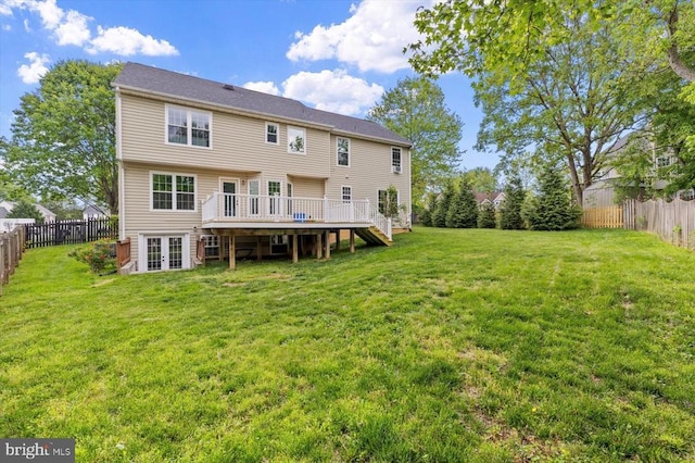 rear view of property featuring a lawn, a fenced backyard, a wooden deck, and french doors