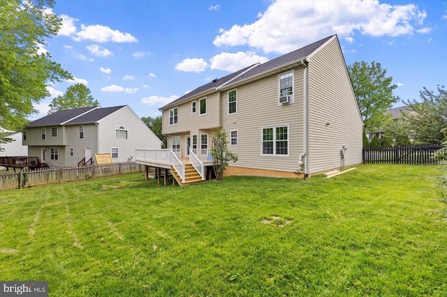 rear view of house featuring a fenced backyard, a wooden deck, a lawn, and stairway