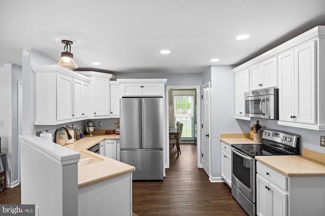 kitchen featuring light countertops, appliances with stainless steel finishes, recessed lighting, and white cabinetry