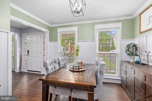 dining room featuring an inviting chandelier, plenty of natural light, a wainscoted wall, and dark wood-type flooring