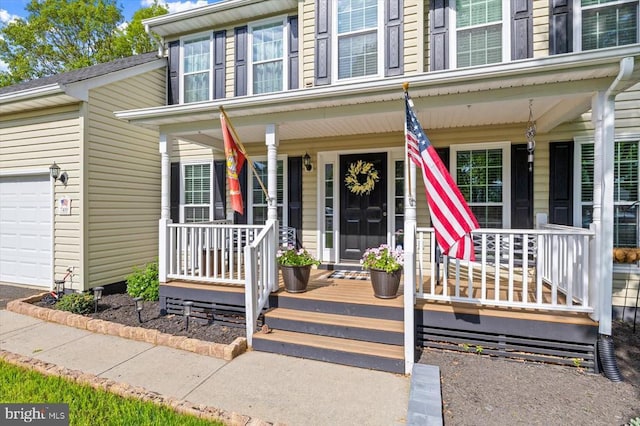 entrance to property featuring a garage and covered porch