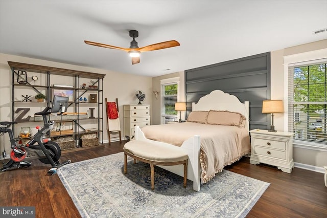 bedroom featuring visible vents, a ceiling fan, baseboards, and dark wood-style floors