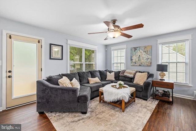 living room featuring baseboards, ceiling fan, and wood finished floors