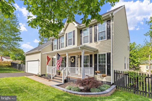 traditional-style home featuring a front lawn, aphalt driveway, an attached garage, fence, and a porch
