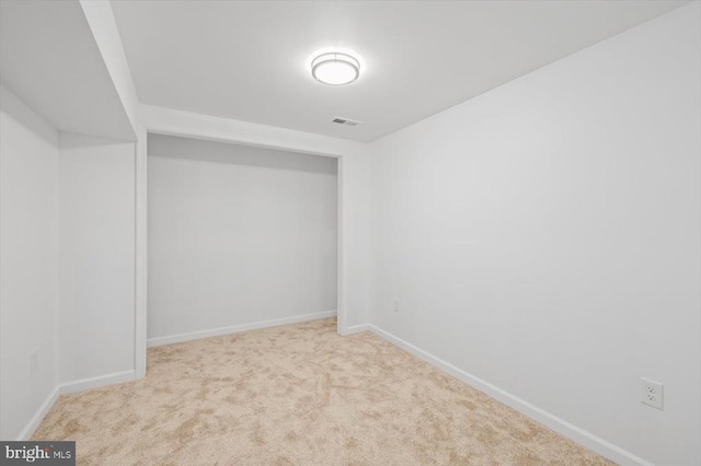 basement with baseboards, carpet flooring, and visible vents