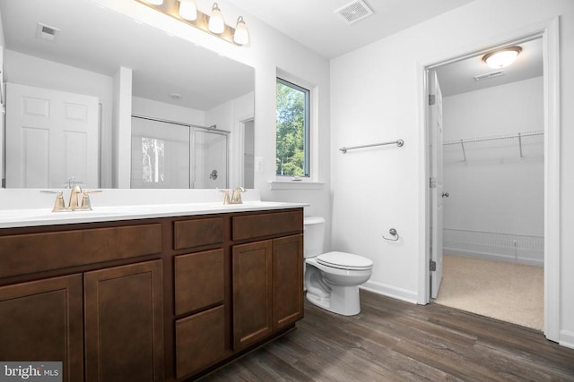 bathroom with vanity, hardwood / wood-style floors, an enclosed shower, and toilet