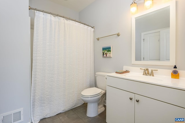 bathroom with tile patterned flooring, vanity, and toilet