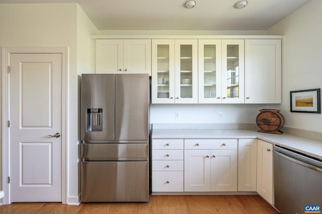 kitchen featuring appliances with stainless steel finishes, light hardwood / wood-style floors, and white cabinets