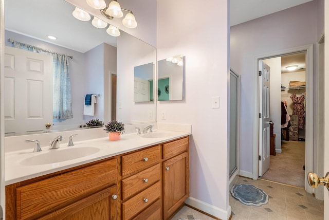 bathroom featuring a sink, tile patterned flooring, a shower stall, and double vanity