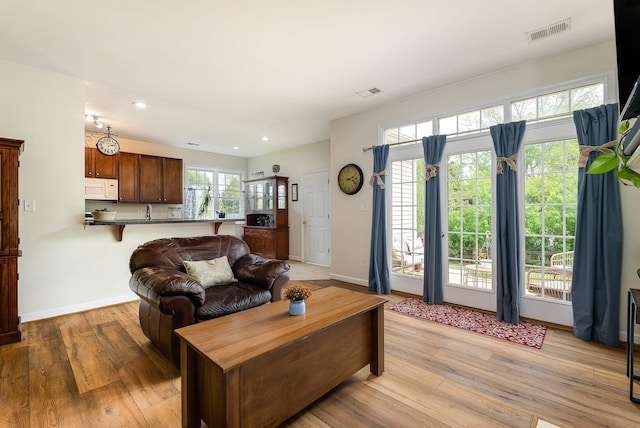 living area with recessed lighting, baseboards, visible vents, and light wood-style flooring