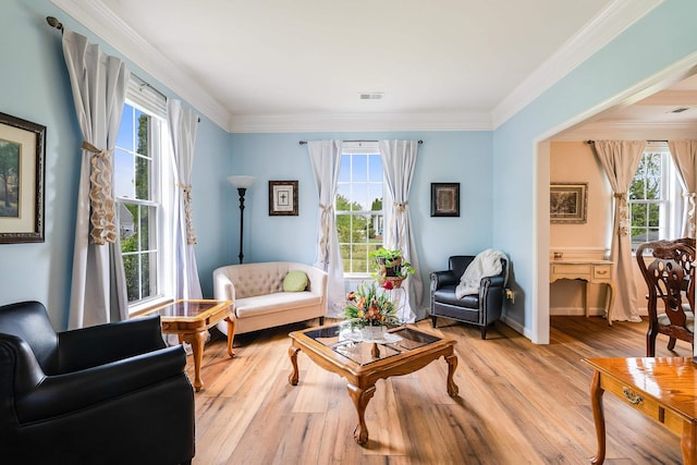 sitting room featuring visible vents, plenty of natural light, ornamental molding, and light wood-type flooring