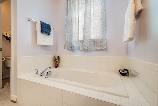 full bathroom with a garden tub and toilet