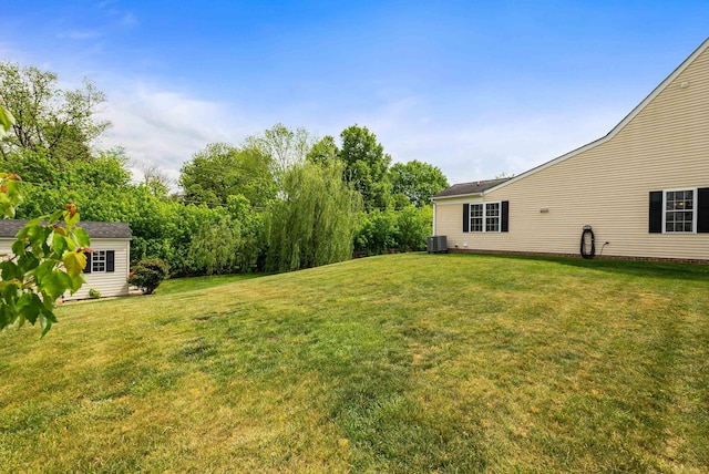 view of yard featuring central AC and an outdoor structure