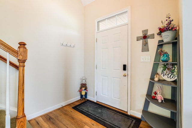 entryway with baseboards, wood finished floors, and stairway