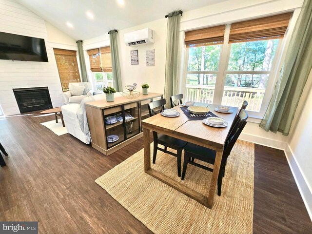 dining room with dark wood-type flooring, a large fireplace, a wall mounted air conditioner, and vaulted ceiling