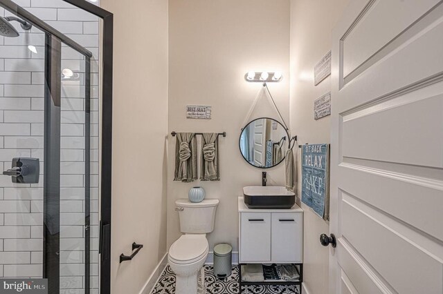 bathroom featuring vanity, walk in shower, tile patterned floors, and toilet