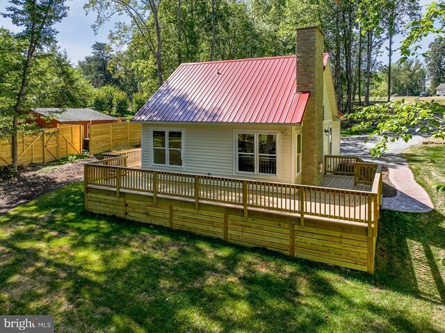 back of property featuring a yard and a deck