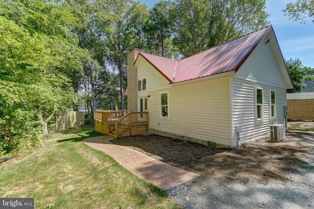 back of house featuring cooling unit, a yard, and a deck