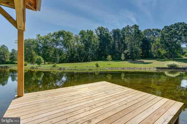 dock area featuring a water view and a lawn