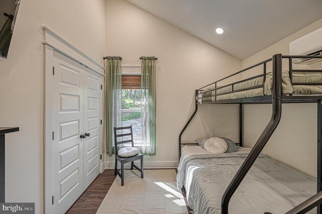 bedroom with hardwood / wood-style flooring and lofted ceiling