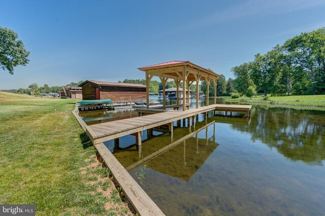 view of dock featuring a water view and a yard