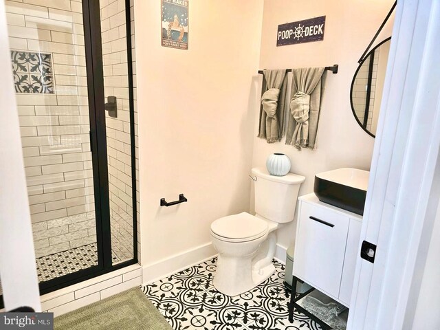 bathroom with vanity, tile patterned flooring, a shower with door, and toilet