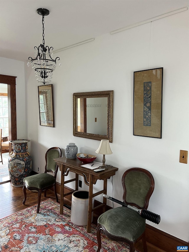 sitting room featuring a notable chandelier and wood-type flooring