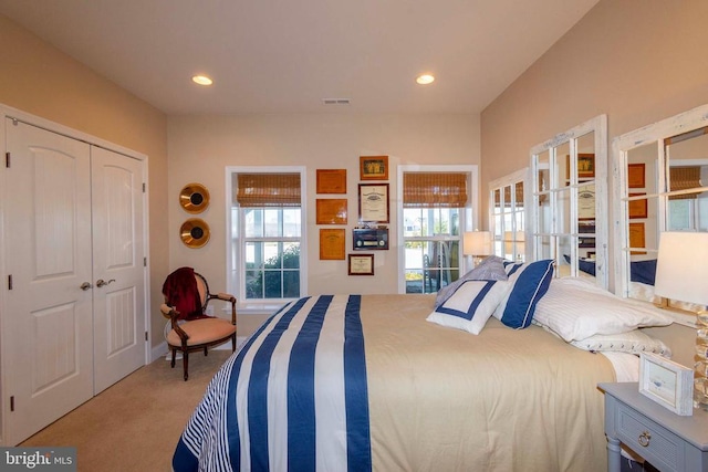 bedroom with a closet, recessed lighting, french doors, and carpet