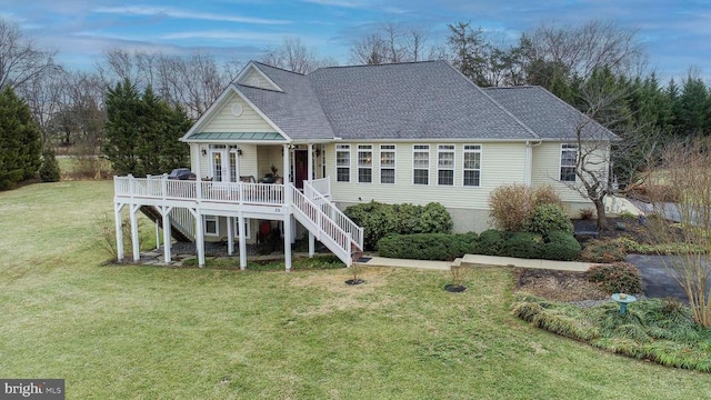 view of front of house featuring stairs, a front yard, french doors, and roof with shingles