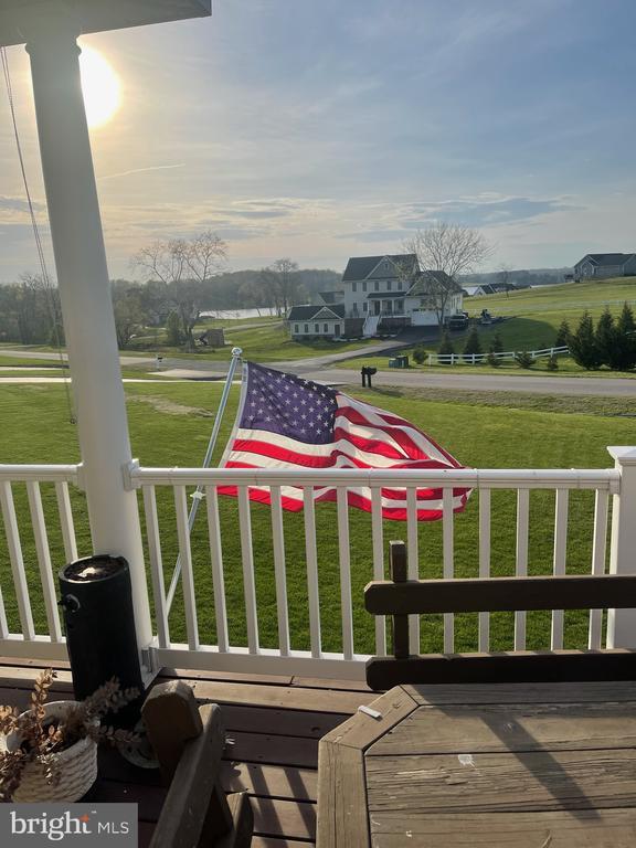 deck with a rural view and a yard