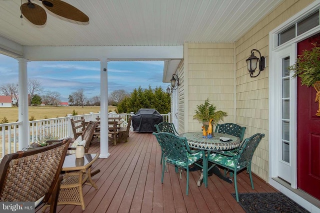 deck featuring a grill, outdoor dining space, and a ceiling fan