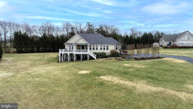 rear view of property with a lawn and stairs