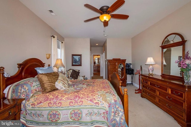 bedroom with baseboards, light colored carpet, visible vents, and ceiling fan