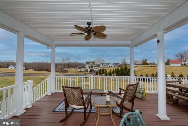 wooden deck with a lawn and ceiling fan