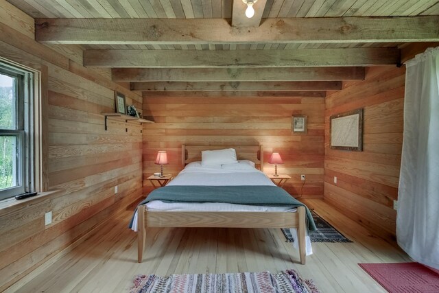 unfurnished bedroom featuring beamed ceiling, wooden ceiling, hardwood / wood-style flooring, and wood walls