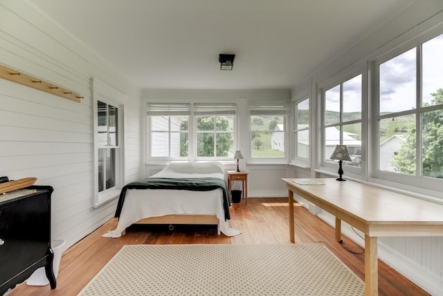 bedroom with multiple windows and hardwood / wood-style flooring