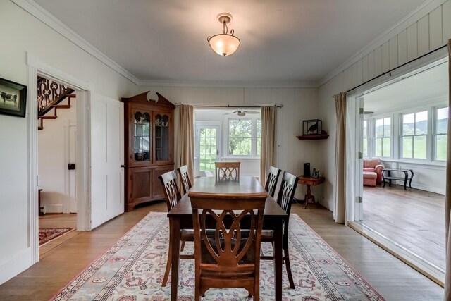 dining space with crown molding and light hardwood / wood-style flooring