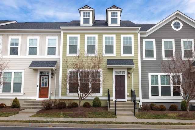 townhome / multi-family property with roof with shingles