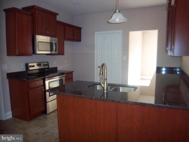 kitchen featuring sink, decorative light fixtures, dark stone countertops, kitchen peninsula, and stainless steel appliances