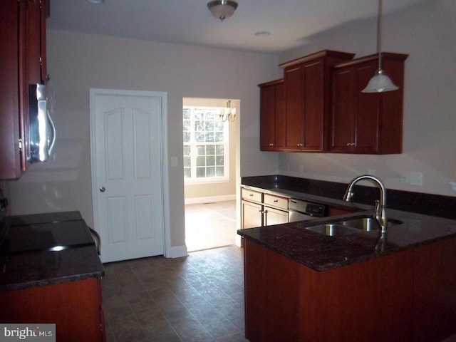 kitchen featuring appliances with stainless steel finishes, kitchen peninsula, sink, and dark stone countertops